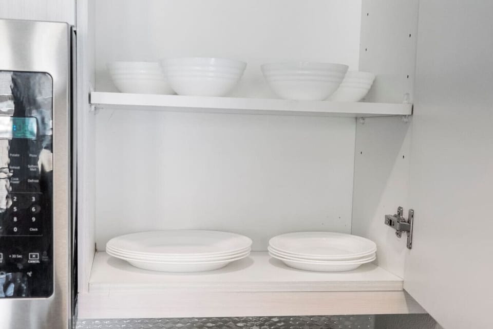 Kitchen cabinets stocked with cooking wares, glassware and silverwares, ideal for mixing up your favorite meals and drinks during your stay.