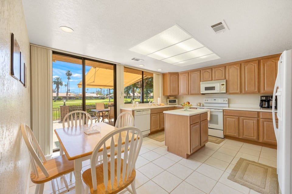 Neutral-toned kitchen area with a dining table that comfortably seats four
