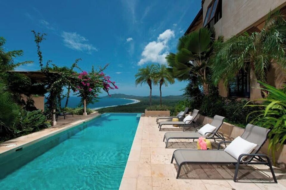 Stunning infinity pool surrounded by lush tropical gardens, offering breathtaking views of Tamarindo’s national park — the perfect spot to relax and unwind during your vacation.