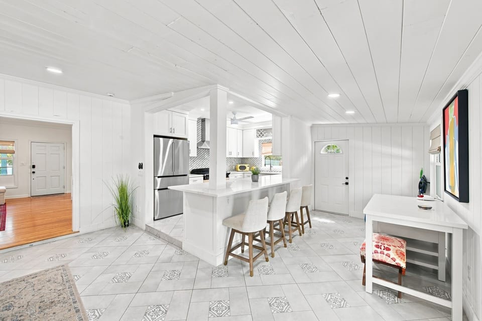 Open-concept kitchen with island seating and stainless steel fridge
