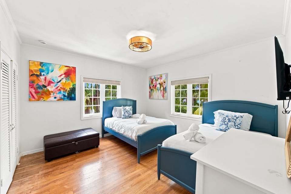 Shared bedroom with two twin beds and vibrant wall art