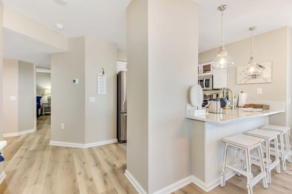 Your bright, open-concept kitchen awaits with modern appliances, elegant pendant lighting, and a breakfast bar perfect for morning coffee.