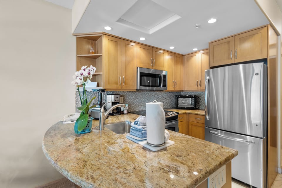 Your fully equipped kitchen features warm wood cabinetry, granite countertops, stainless steel appliances, and everything you need to prepare delicious meals during your stay.