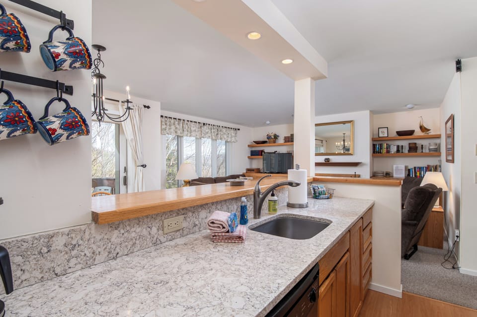 - Kitchen with stone counters and open breakfast bar - Bright layout overlooks dining and living spaces - Ideal for cooking and connecting with family nearby