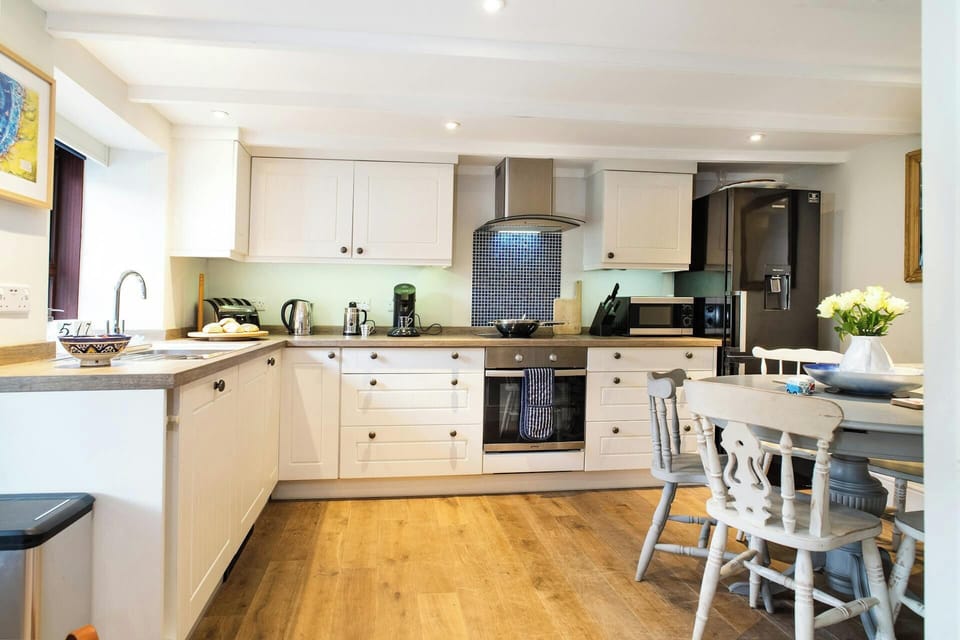 Fitted kitchen/dining area: built-in oven and hob, fridge/freezer, kettle, toaster and microwave: table and chairs