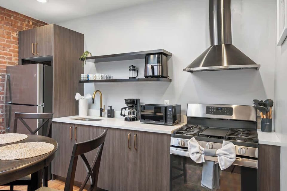 Sleek open kitchen with stainless steel appliances and breakfast table


