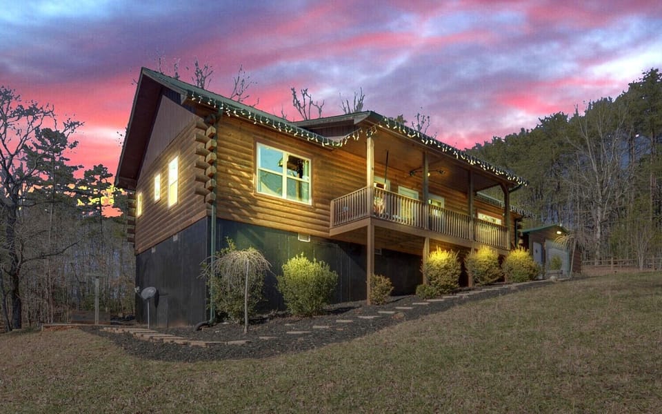 This charming log cabin features a spacious back and front porches, manicured landscaping, and serene forest views, perfect for a peaceful mountain escape.