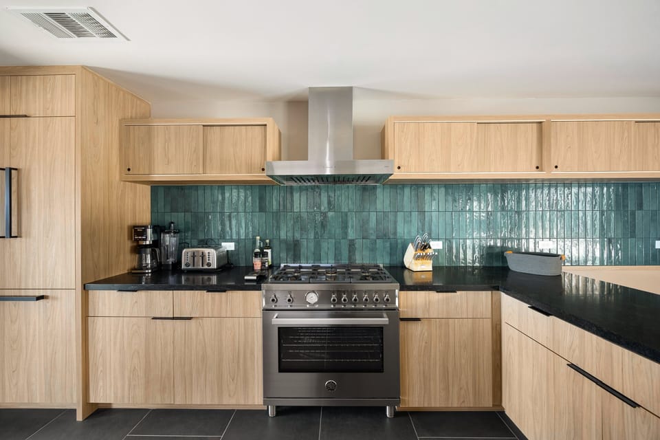Sleek cooking space with warm wood cabinetry and modern finishes.