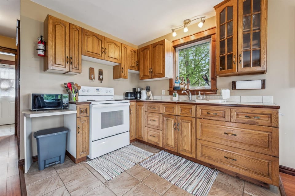 The kitchen boasts solid oak cabinetry, a full suite of appliances, and ample space for preparing meals together.