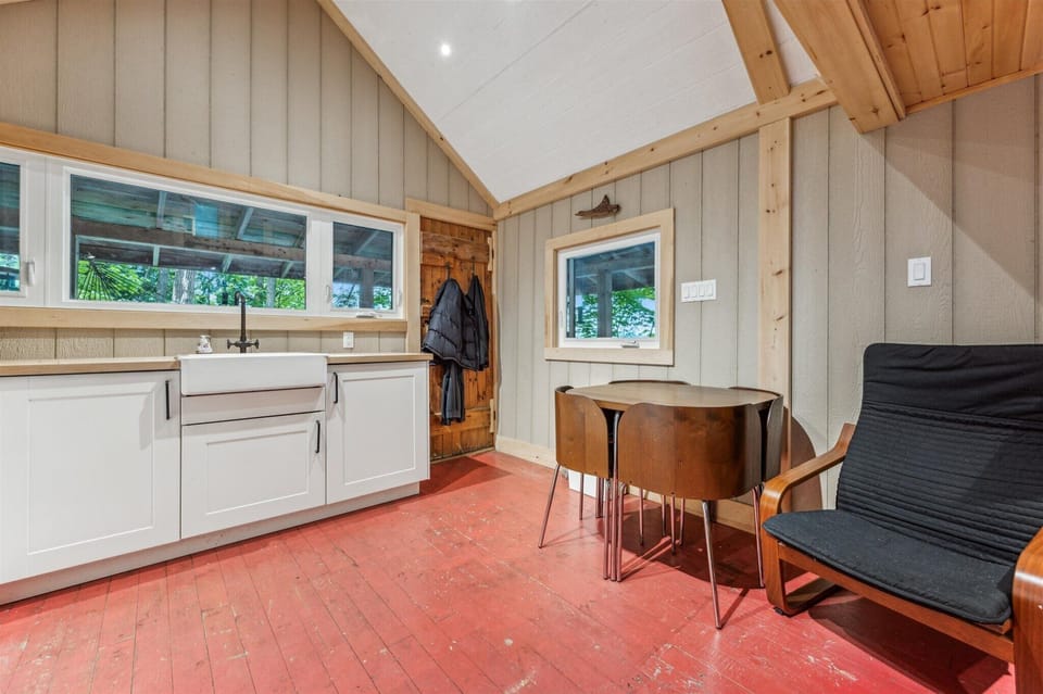 A practical space for sharing meals, hanging jackets, and coming and going from the covered deck just outside. The rustic wood tones and compact layout add to the cottage's charm.
