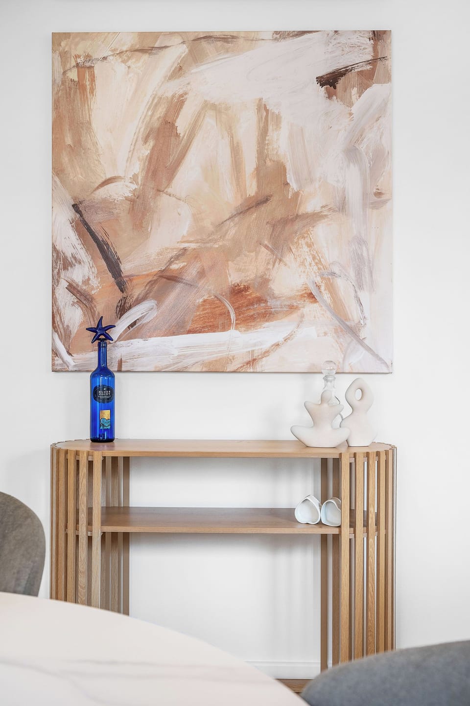 Modern entryway with an abstract art piece, stylish console table, and decorative accents.