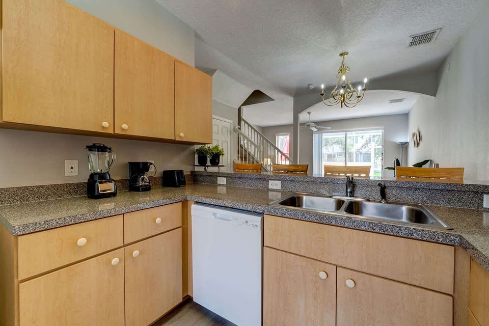 Modern kitchen with granite countertops and a view into the dining area.