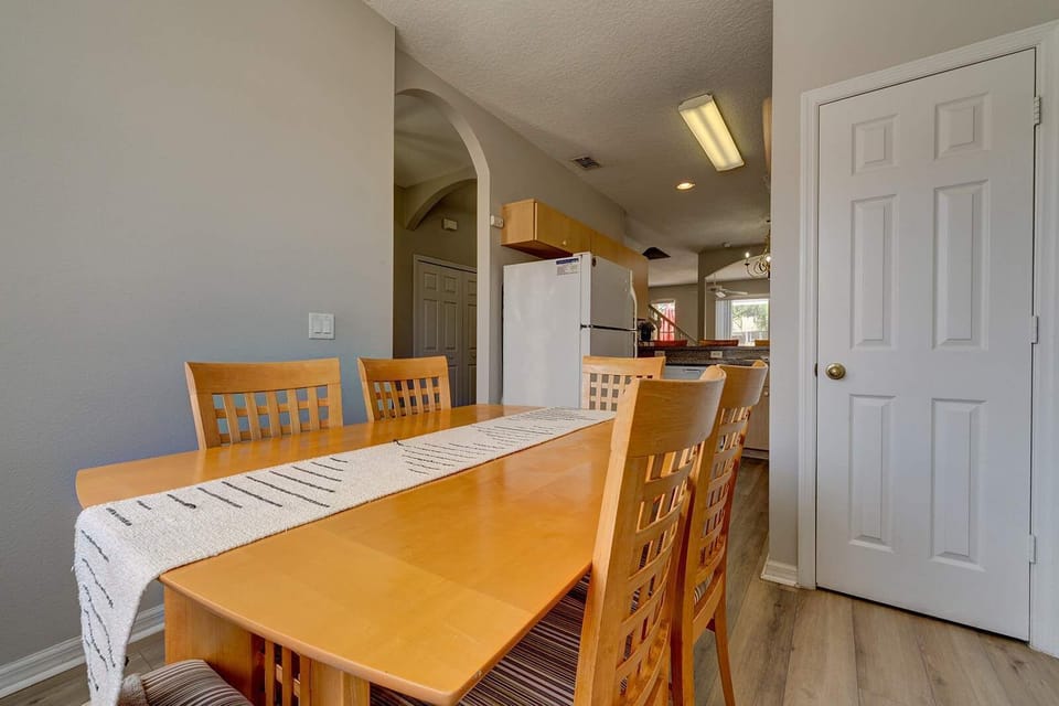 Dining area with wooden table and chairs adjacent to the kitchen.