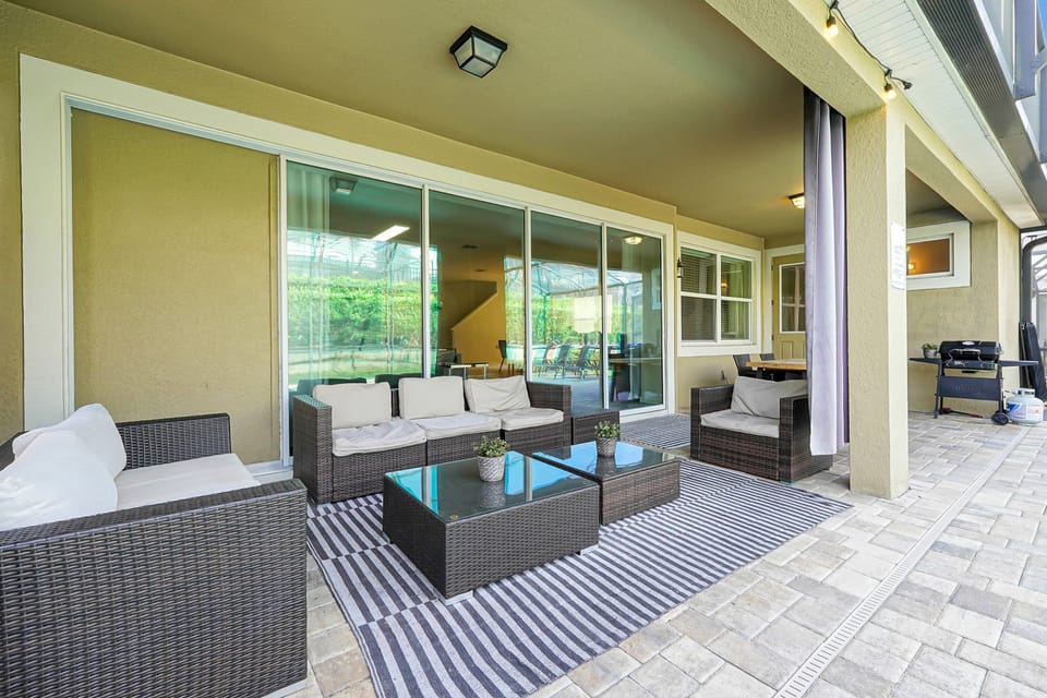 Relax poolside under the covered lanai with comfortable seating, perfect for morning coffee, outdoor dining, or unwinding after a day at the parks.