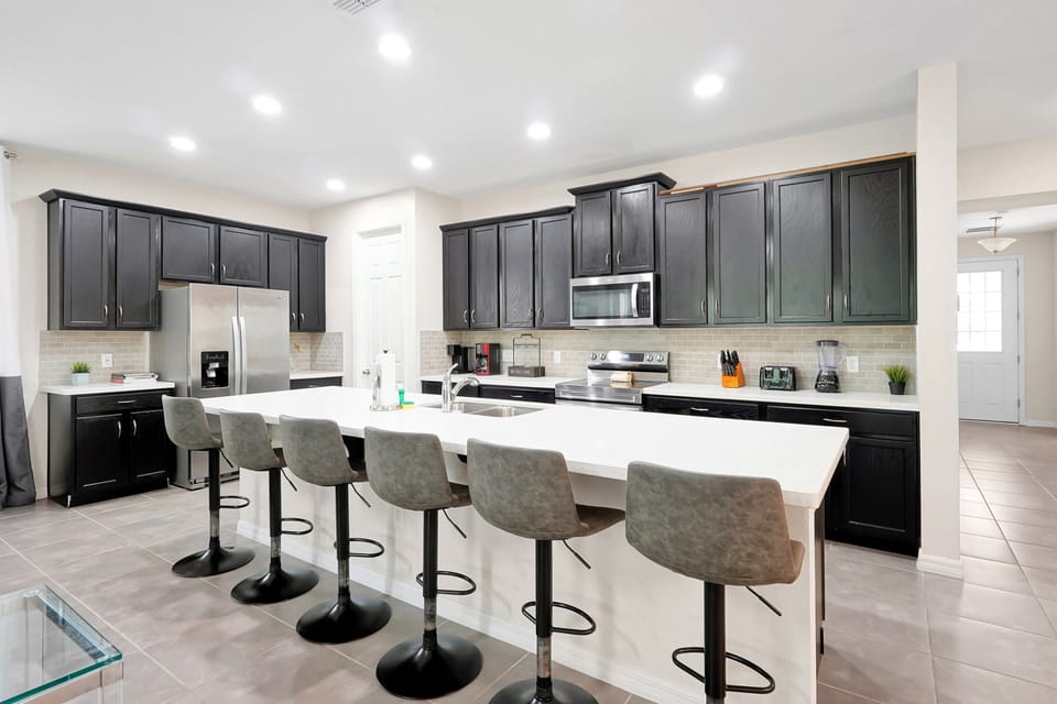 Prepare meals with ease in the spacious kitchen featuring ample counter space, modern appliances, and seating for the whole group.