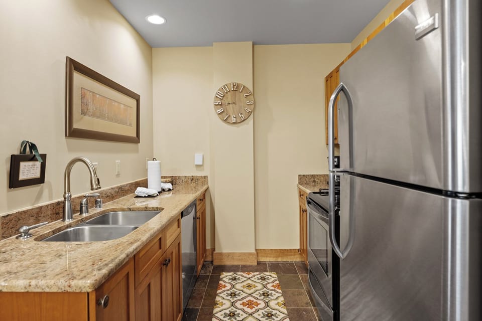 Your fully equipped kitchen features granite counters, stainless appliances, and warm wood cabinets—perfect for preparing meals during your stay.