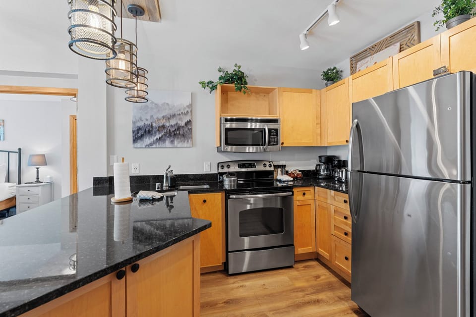 Your fully equipped kitchen invites home-cooked meals with gleaming granite counters, stainless appliances, and warm wood cabinets creating the perfect culinary retreat.