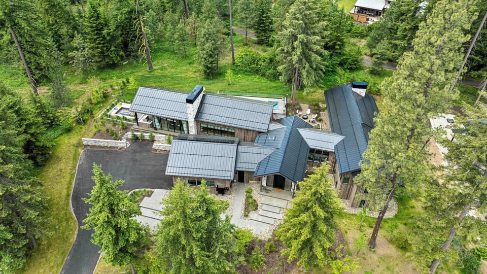 A dramatic modern lodge unfolds into multiple wings of luxury living, surrounded by evergreens and open air serenity.