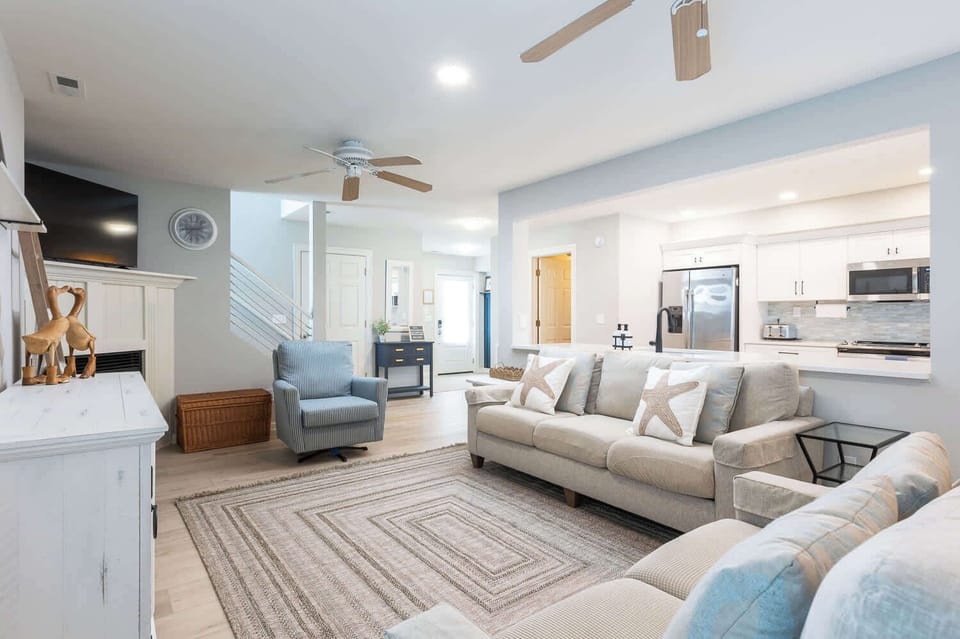 Bright, open living room with a large TV and comfy seating