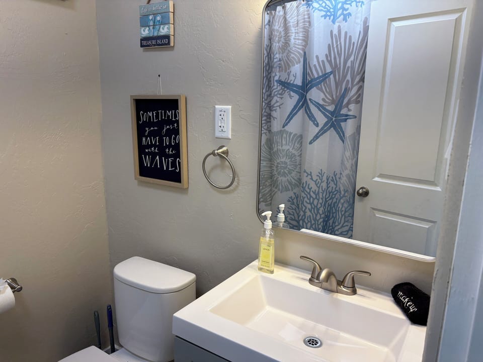 Full bathroom with hair dryer, shampoo, conditioner, body wash and towels 