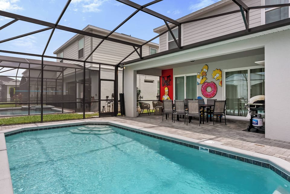 Step outside to your own private oasis, featuring a crystal-clear pool surrounded by a spacious deck. Vibrant artwork adds a splash of color to the inviting atmosphere, while ample seating invites you to unwind in the sun.