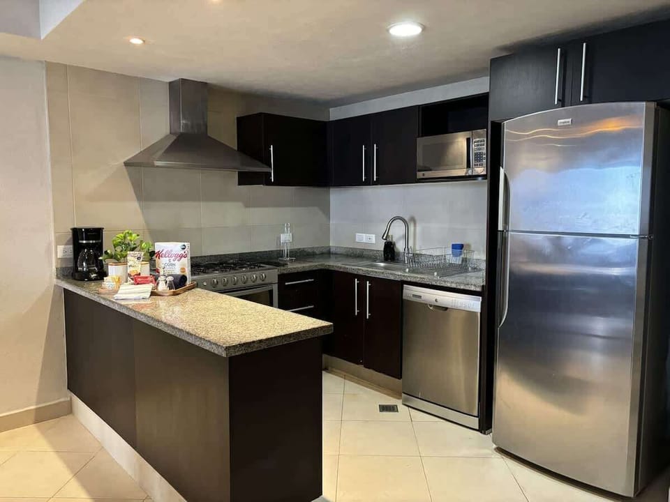 A fully equipped kitchen featuring a coffee maker, dishwasher, toaster, and all essentials for a convenient stay. Enjoy complimentary snacks and drinks upon arrival as a welcome treat!