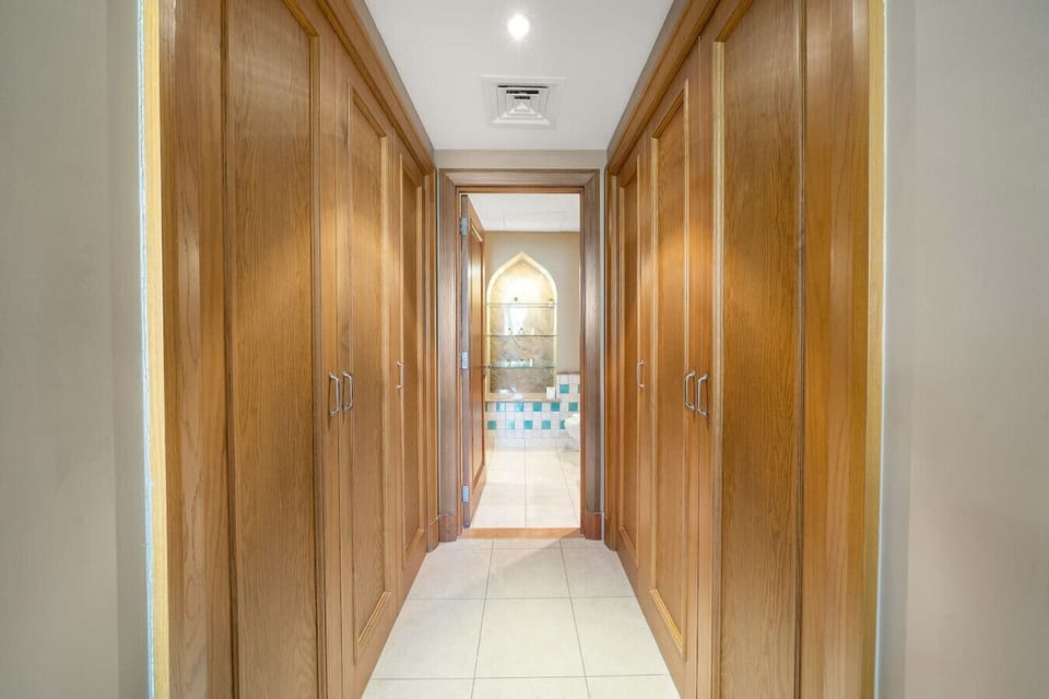 Hallway Retreat: Elegant wooden cabinetry leads you to luxurious comfort and vibrant decor!