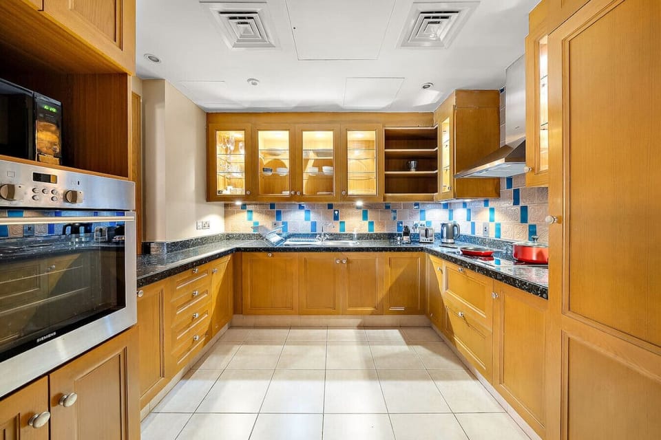 Kitchen: Prepare gourmet meals in a modern space with stylish details and vibrant tile accents!