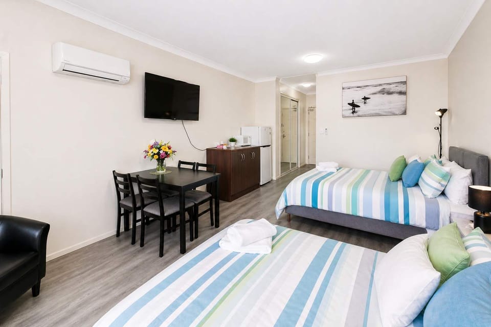 Comfortable sleeping area with premium bedding
Dining table inside studio apartment, perfect for meals and work
