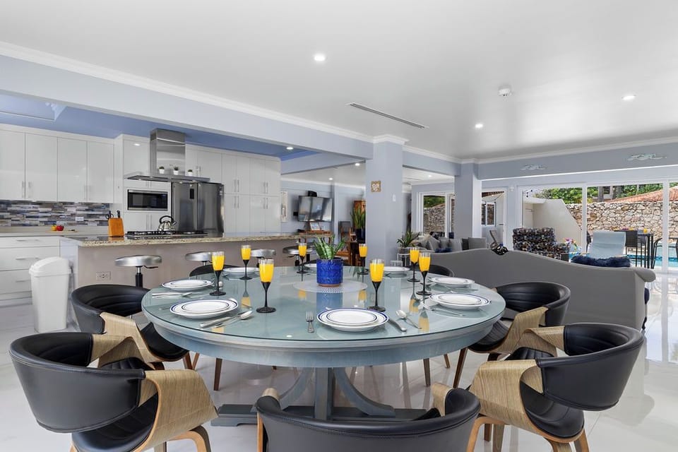 Fully equipped indoor kitchen with stainless steel appliances, island seating for 6, and dining space for 8—ideal for family meals and entertaining.