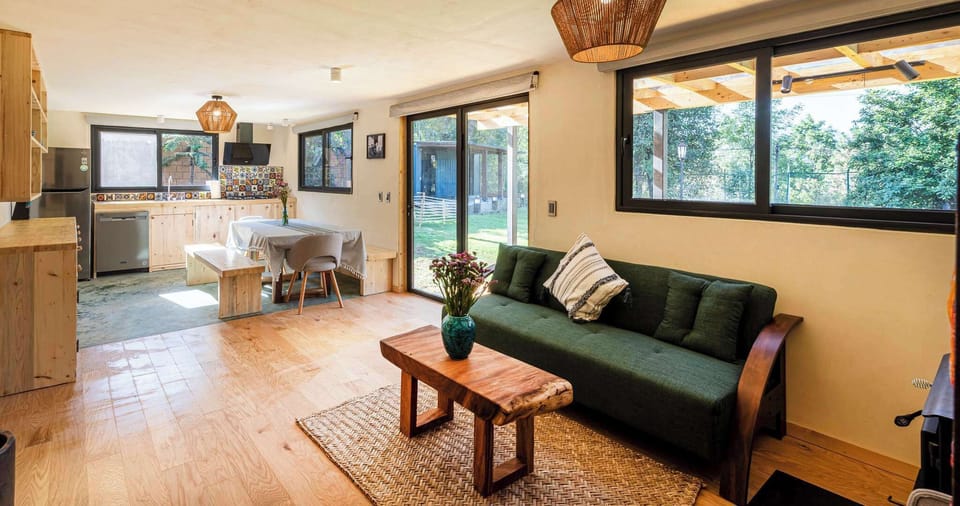 Sala de estar con cocina completa y chimenea de leña 