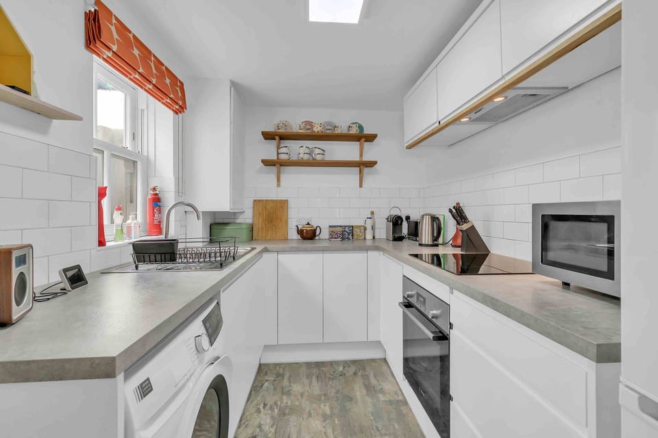 Modern fully equipped kitchen with sleek white cabinets and natural light