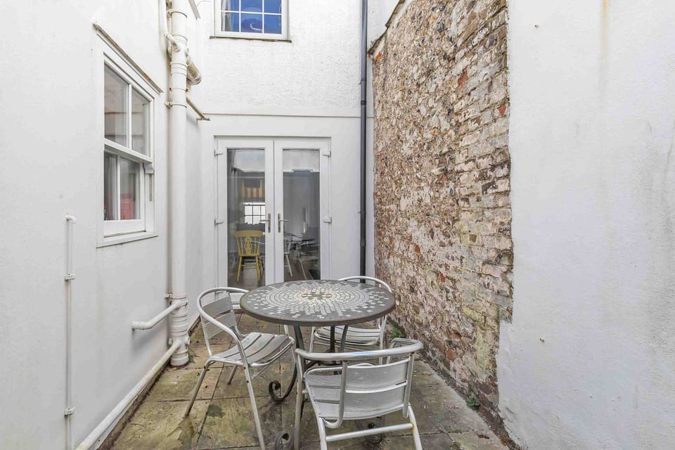 Private courtyard with outdoor seating, exposed brick wall, and rustic charm