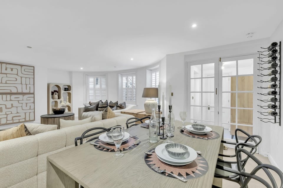 Compact dining area with modern table and four chairs, set for a cosy meal or work session.