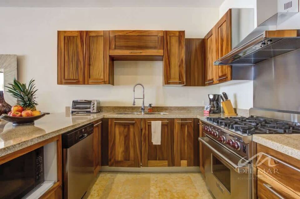 Modern kitchen w/ wraparound counters, wood cabinets & ample space for cooking together.