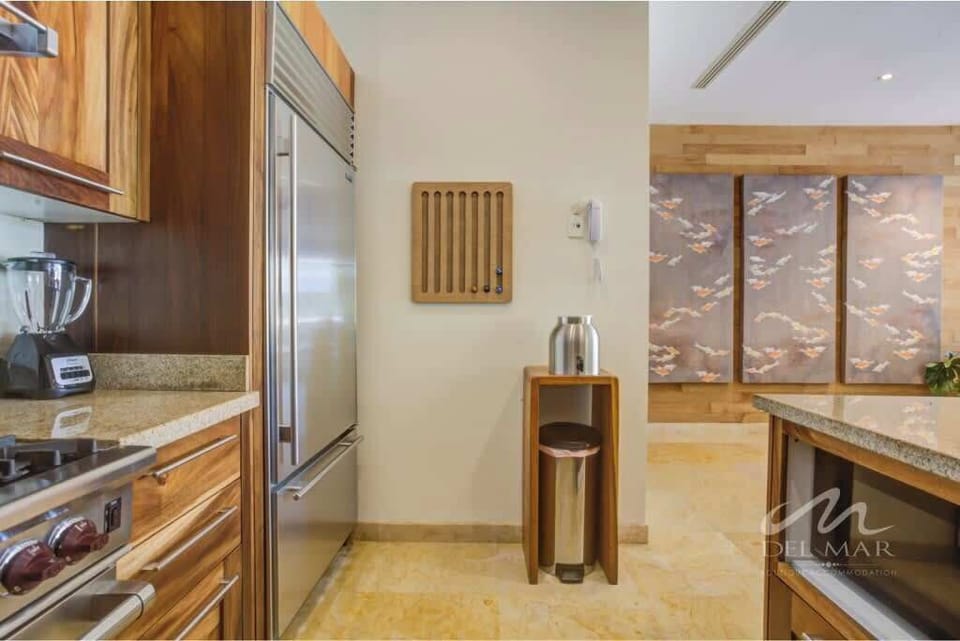 Bright kitchen corridor w/ sleek counters leading toward the dining area.
