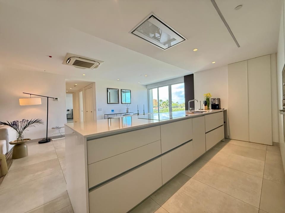Your spacious kitchen features sleek white cabinetry, modern appliances, and a large island perfect for cooking and entertaining.