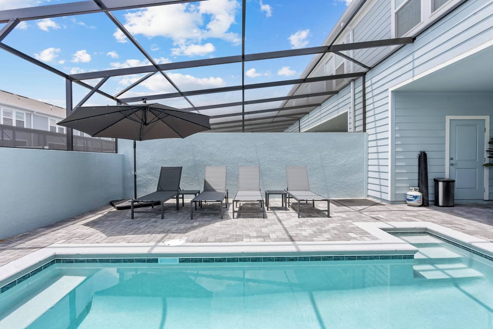 Step outside to enjoy the sunny patio with sleek lounge chairs by the shimmering pool. The covered area offers comfort and shade, making it the perfect spot to relax after your day's adventures.