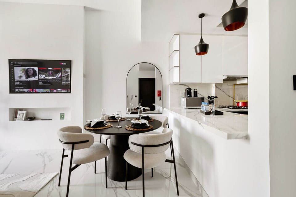 Modern dining area and kitchen with sleek finishes and built-in appliances.
