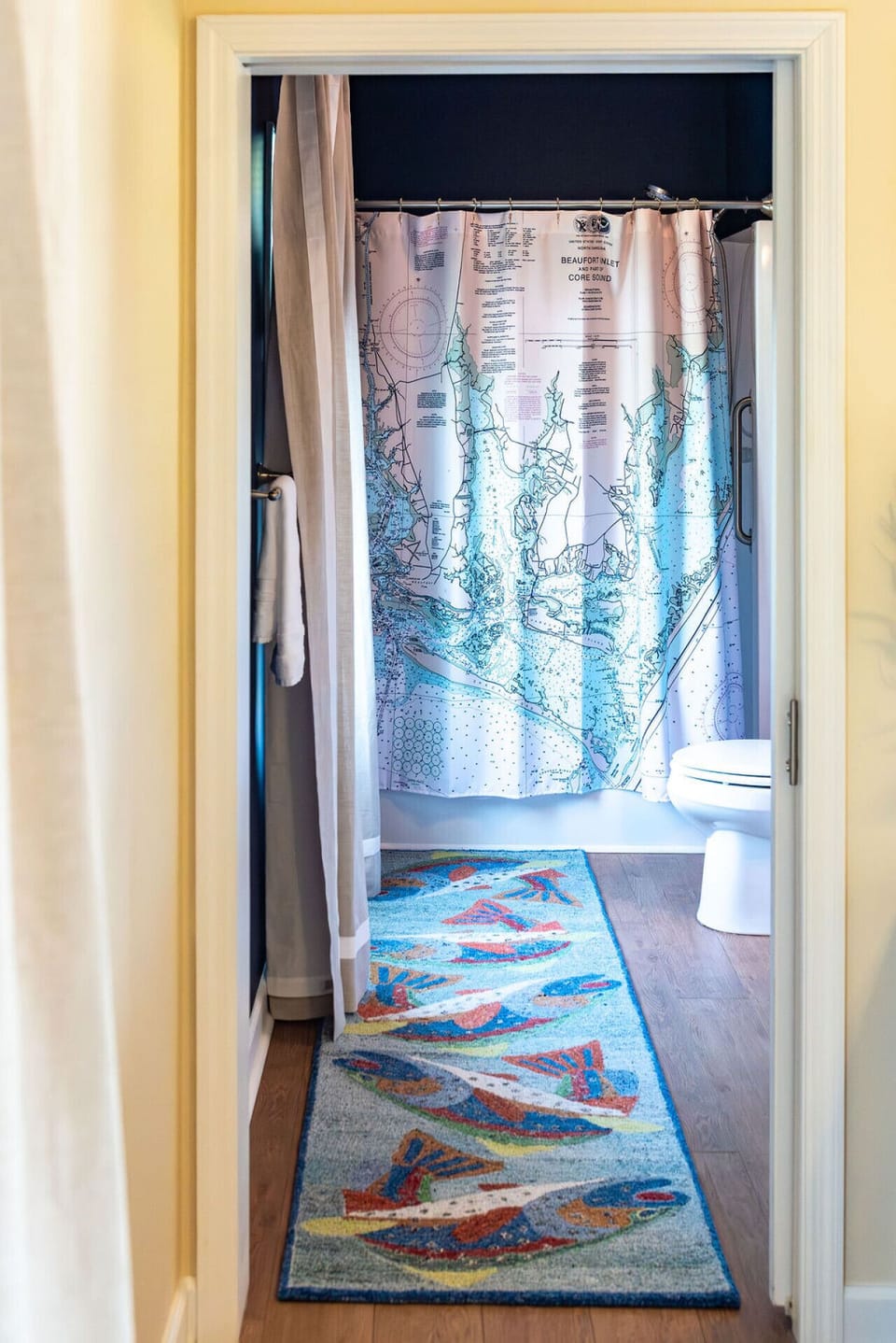 Primary bathroom featuring a shower area and charming coastal-themed curtain details