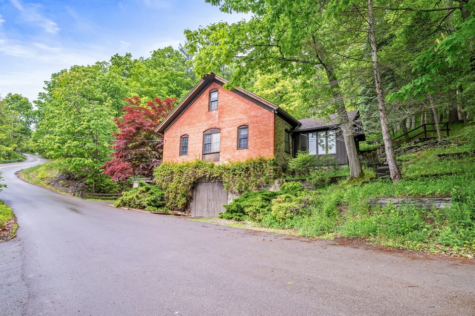 A classic brick and stone facade tucked into nature—character and charm await 🍂🏠🍃