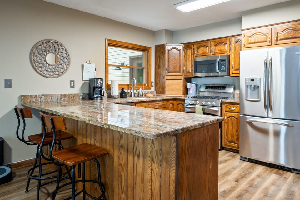 Spacious kitchen with granite countertops, stainless steel appliances, and bar seating for casual dining or entertaining. 🍳🥂✨