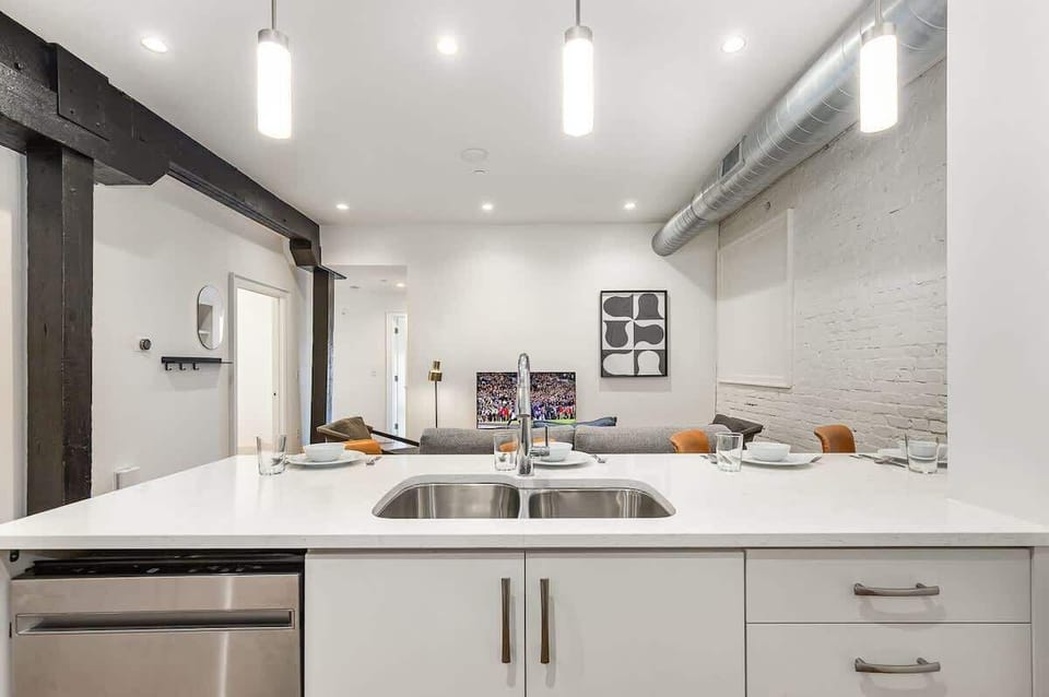 Fully equipped kitchen featuring stainless steel appliances, open counter space, and bar seating for 5 guests.