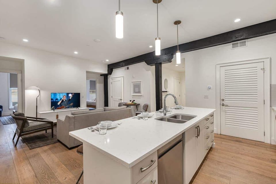 Kitchen with stainless steel appliances, white cabinetry and countertops, a central island, and breakfast bar seating for 4.
