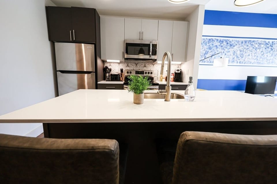 Enter our compact kitchen boasting sleek design elements. Neutral tones blend to form an aesthetically pleasing and functional space, catering to guests seeking both style and practicality