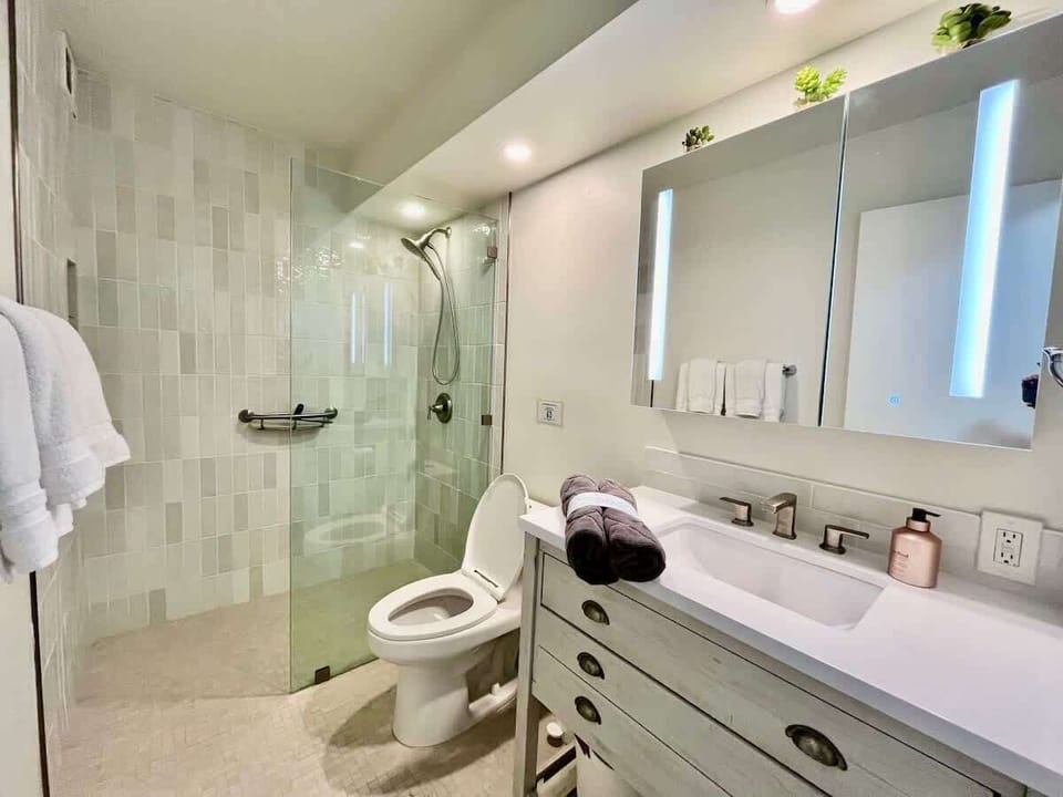 Deluxe shower next to primary bedroom shared with guest bedroom with twin beds