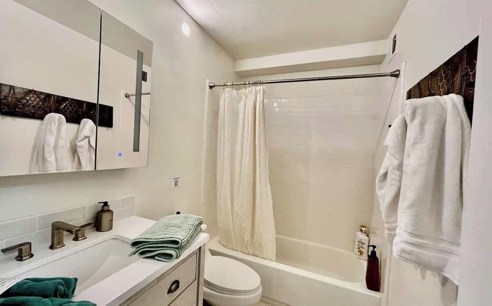 Shared bathroom with tub and shower for guest bedroom with queen