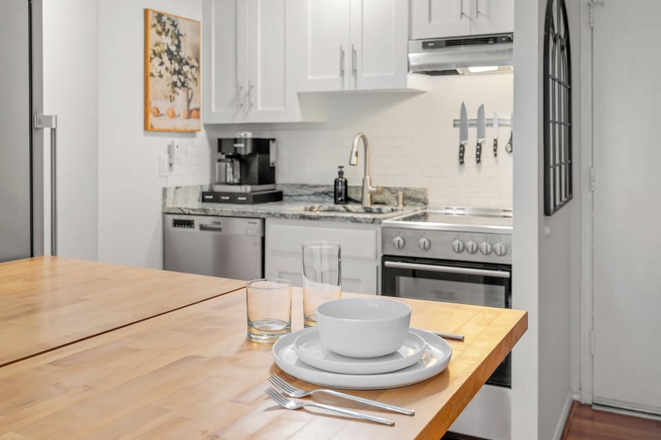 Kitchen with stainless appliances, drop-leaf counter, and full dining set.