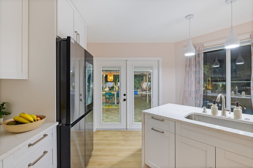 Bright, open kitchen with seamless flow to tropical dining oasis.