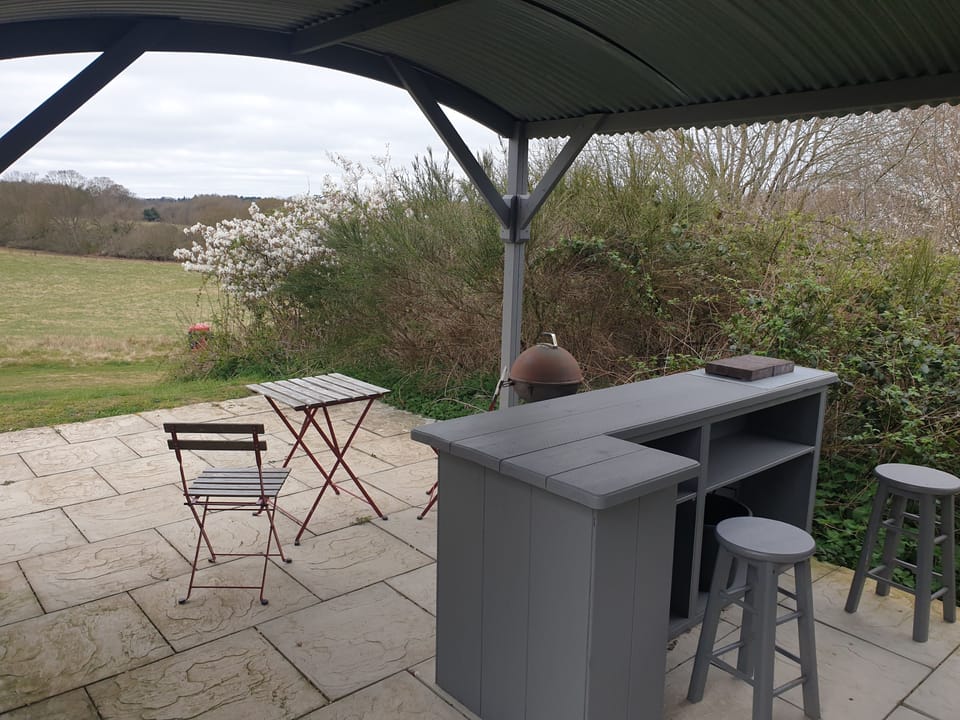 Grill & Chill Shack with a bar with stools, table and seating for two and barbecue area with space for a disposable barbecue too